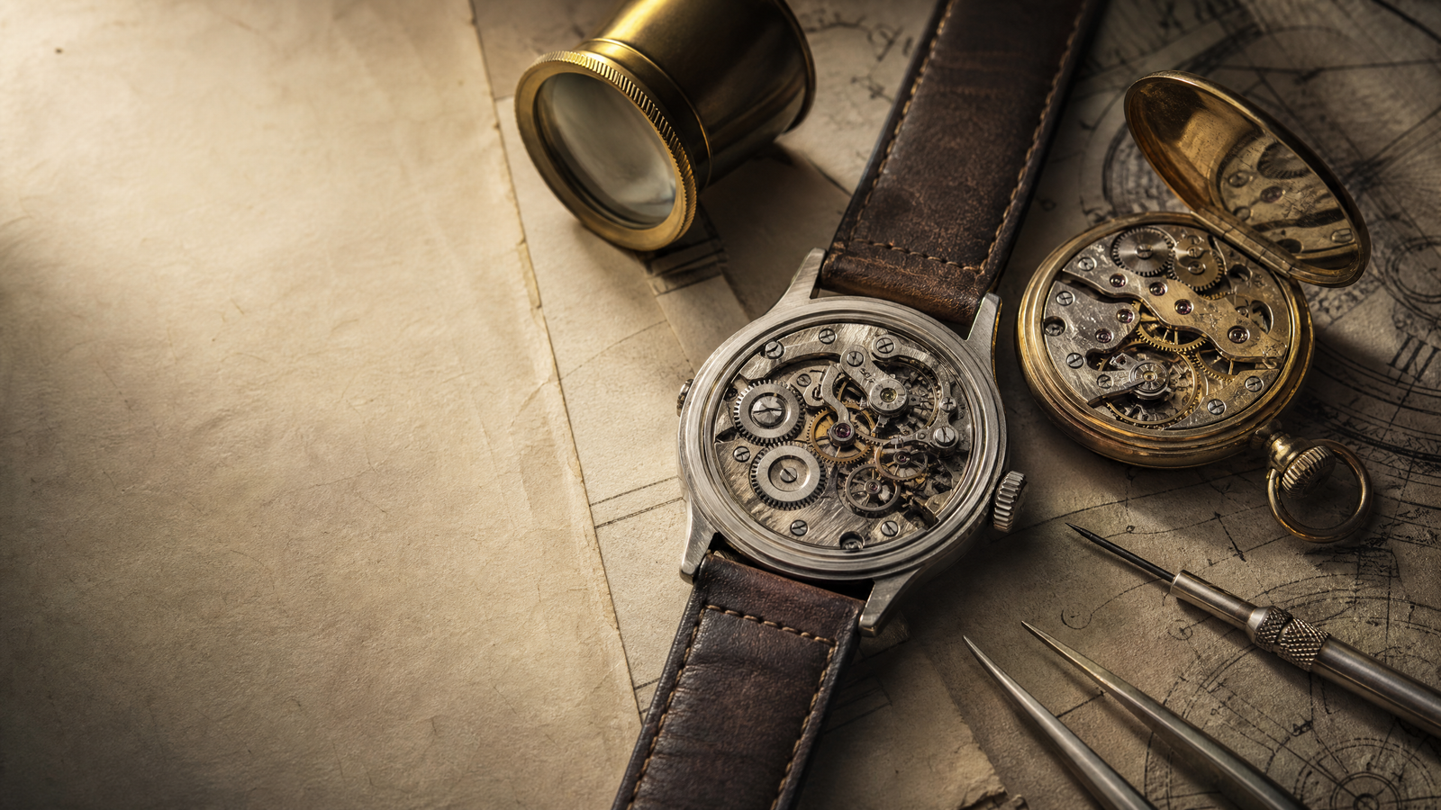 Vintage mechanical watch and watchmaker loupe on archival papers